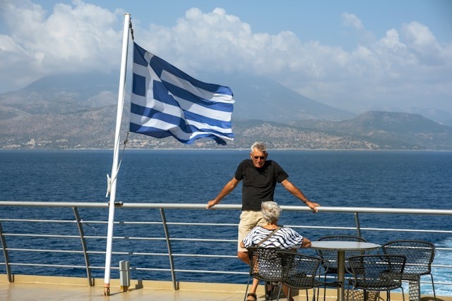 A man on a ferry with a greek flag